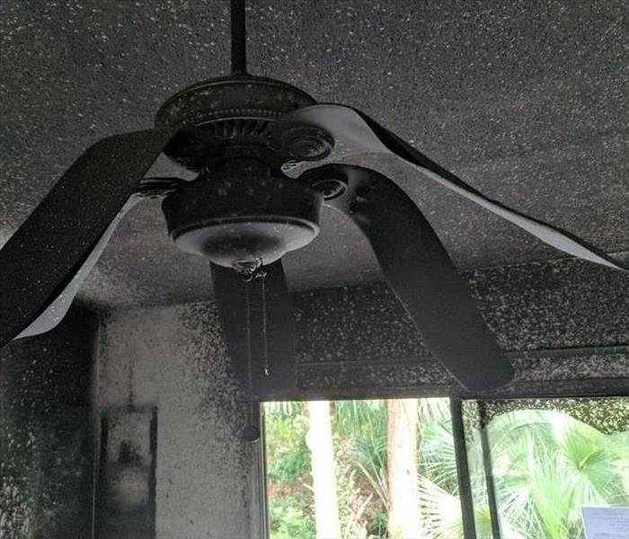 ceiling fan with melted and bent paddles from the heat of a fire in the room
