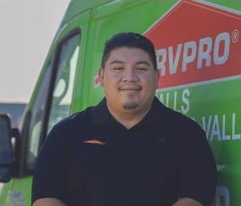 Photo of a man in front of green SERVPRO van