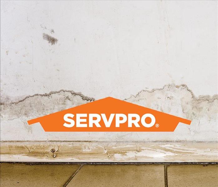 water damaged wall with orange SERVPRO logo