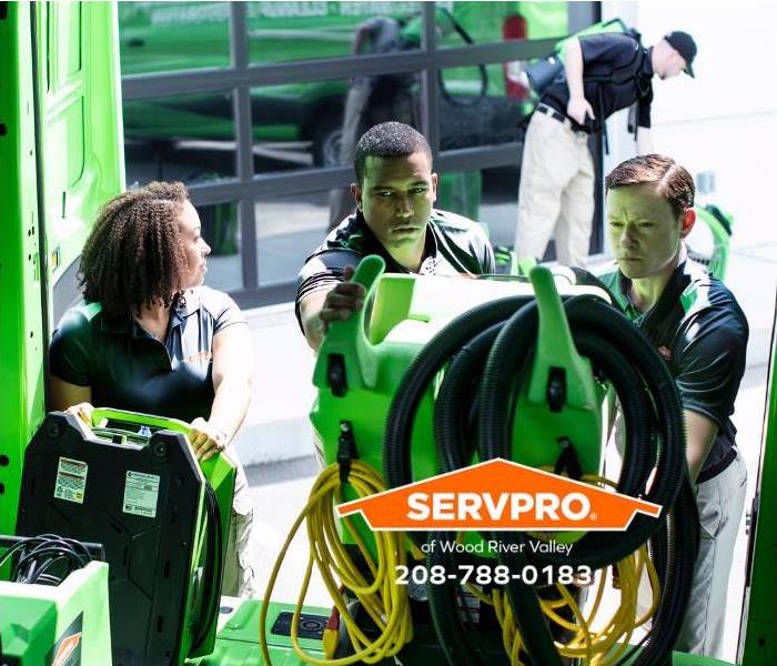 SERVPRO professionals are loading equipment into a service vehicle.
